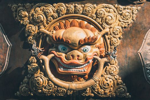 Close-up of a vibrant and detailed traditional Asian sculptural artwork with an ornate and expressive face.