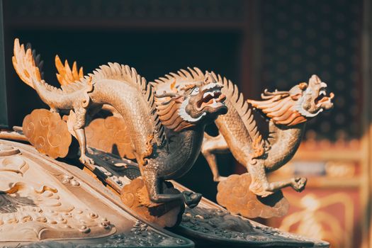 Detailed close-up of ancient eastern dragon sculptures with rich historical texture.