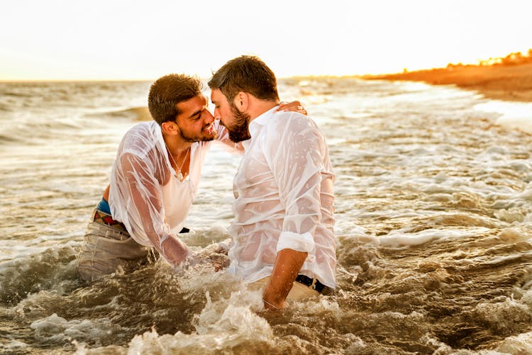 A Same Sex Couple In White Long Sleeves On The Beach