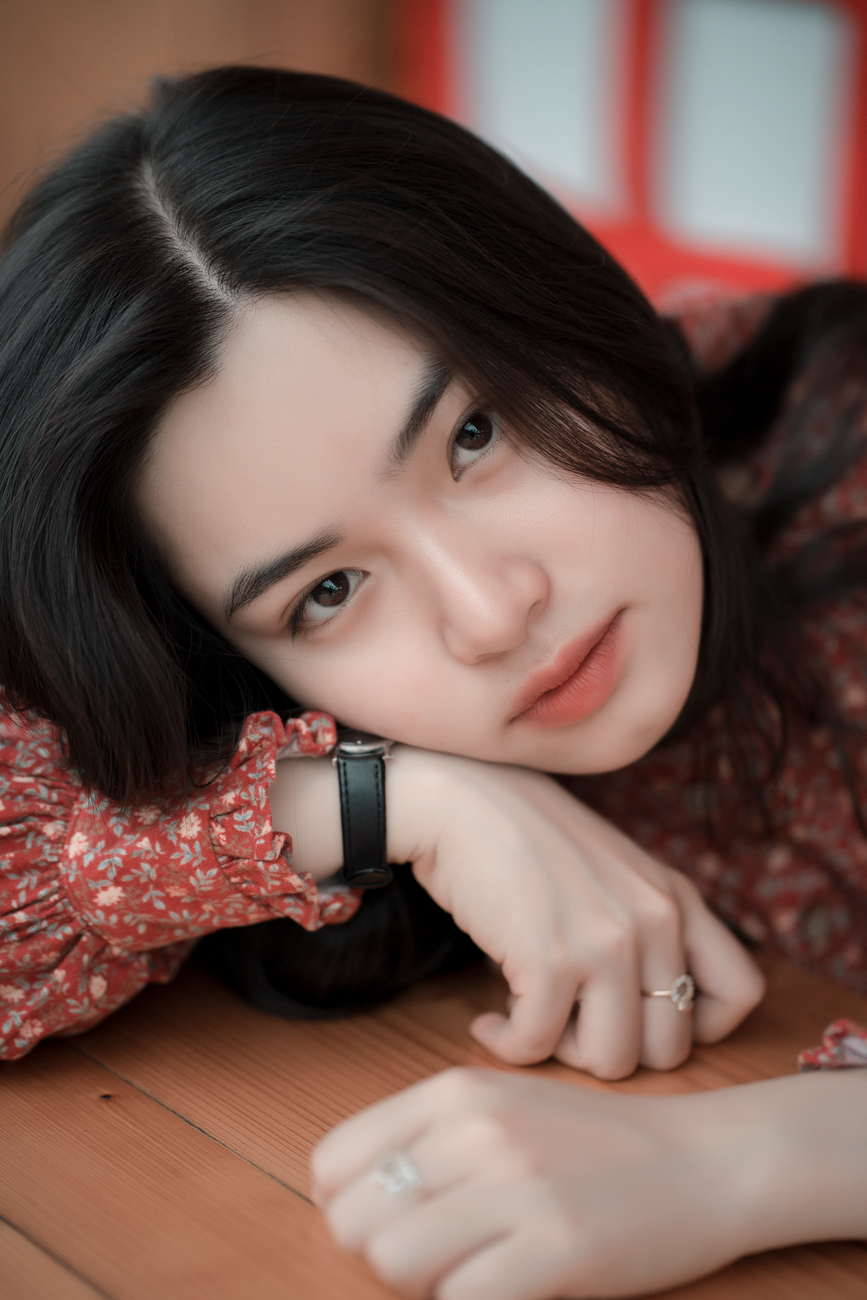 Close-up portrait of a young woman with black hair and a thoughtful expression.