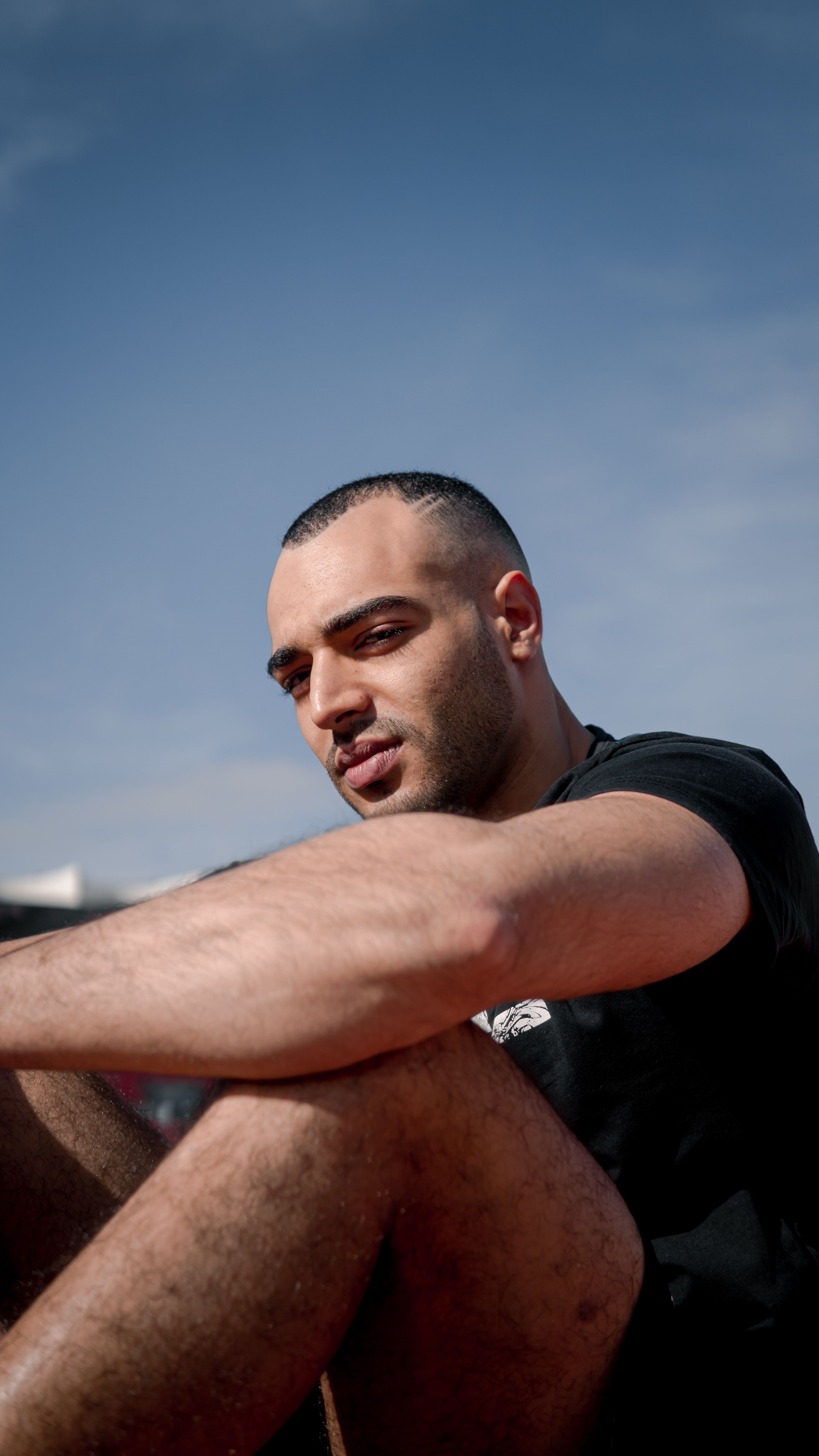 Portrait of a young man in a relaxed pose outdoors in Fes, Morocco.