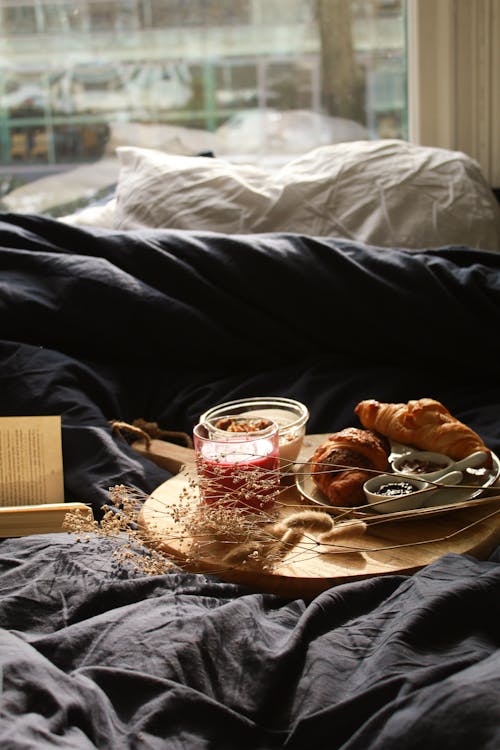 Free Croissants on Wooden Tray near a Bed  Stock Photo