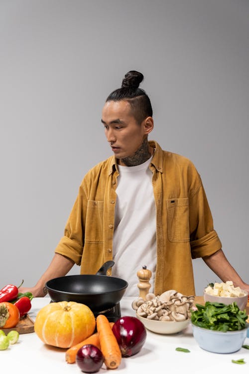 Man in Mustard Yellow Corduroy Jacket Standing near a Table with Vegetables 