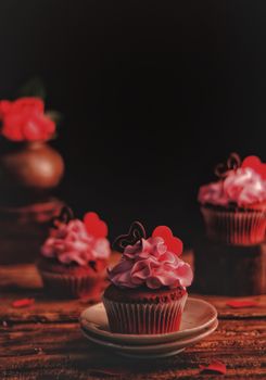Tantalizing cupcakes adorned with pink icing and heart decorations, perfect for celebrations.