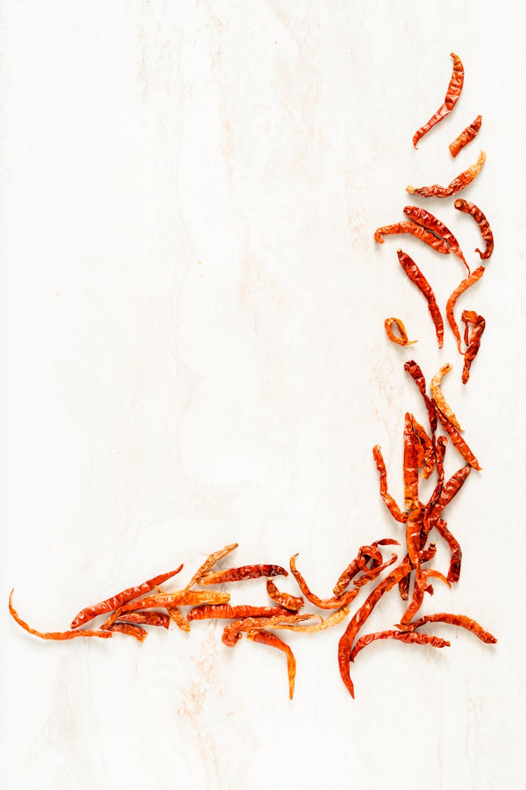 Dried Chili Peppers On White Surface 