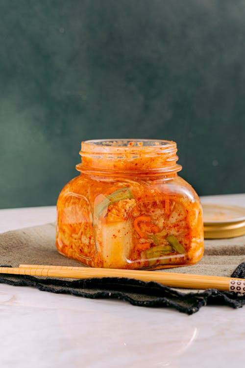 Free Clear Glass Jar with Kimchi beside the Wooden Chopsticks Stock Photo