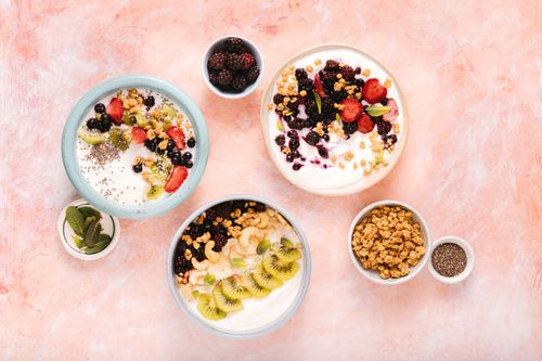 Free Vibrant overhead shot of yogurt bowls topped with assorted berries, nuts, and chia seeds. Stock Photo
