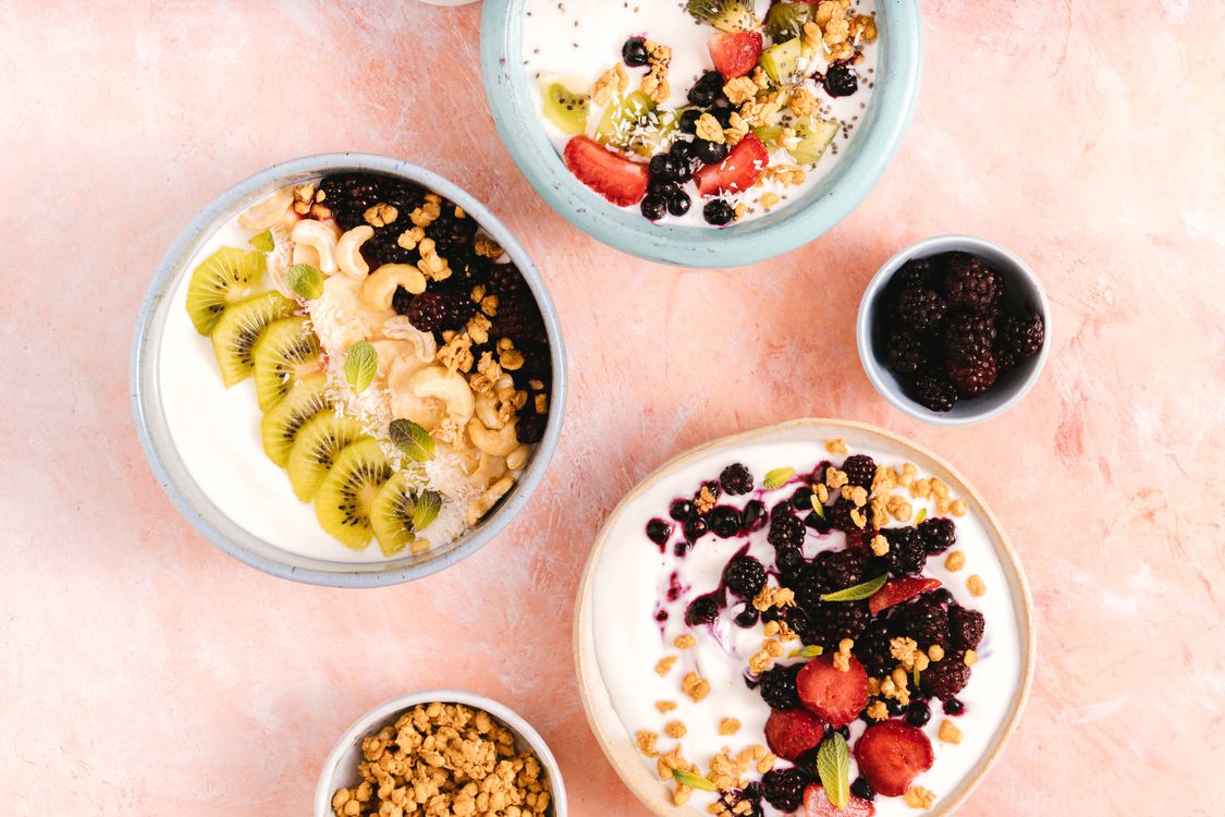 Bol de fruits frais et granola tenu par des mains : alimentation favorable au microbiote intestinal