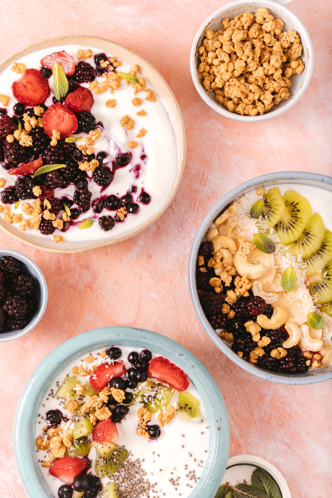Real breakfast and snack bowls with fresh fruit, nuts, and granola