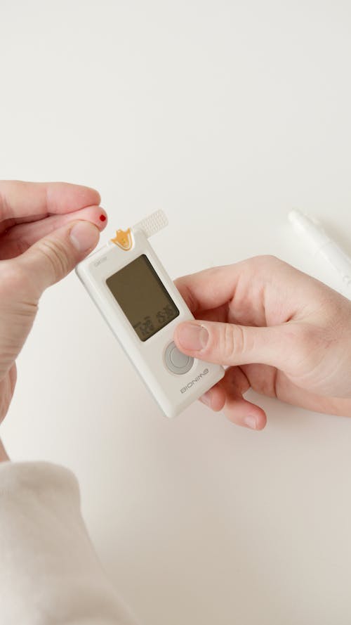 Free A Finger with Blood Beside Glucometer Stock Photo