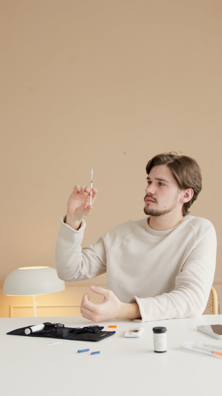 Man In White Long Sleeve Shirt Holding A Syringe With Insulin