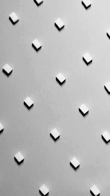 Minimalist monochrome pattern featuring raised diamond shapes on a textured surface.