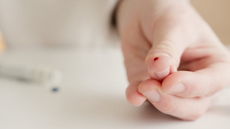 Person With Tiny Blood On Finger After A Blood Test