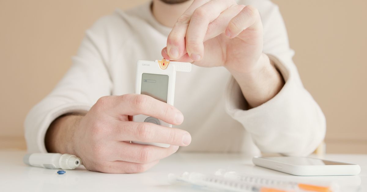 Woman checking a blood glucose meter at home