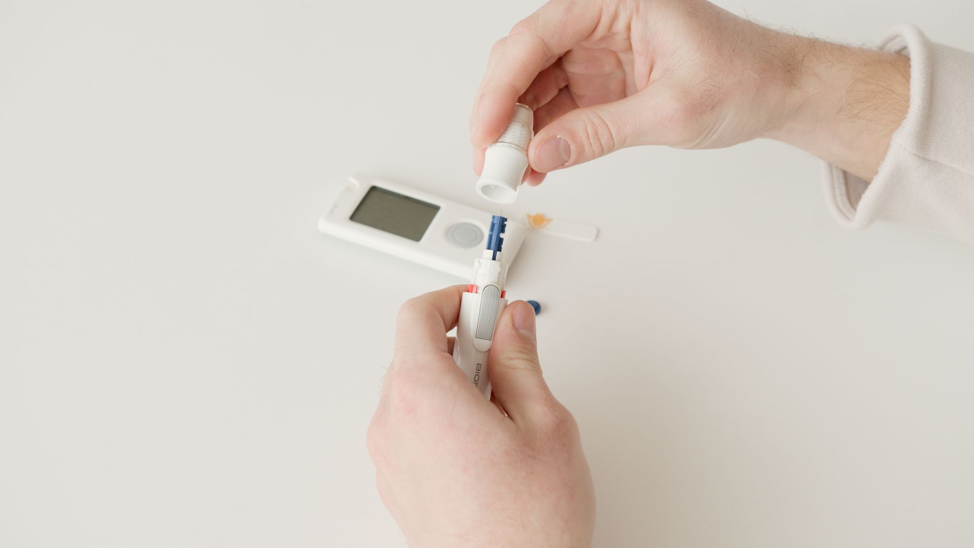 Person Holding White Blood Sugar Tester