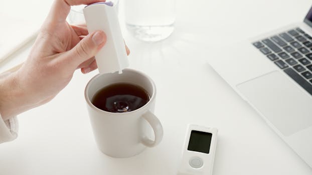 Close-up of a hand adding sweetener to coffee, ideal for diabetic care.