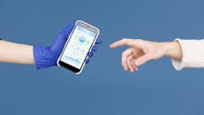 Person wearing Latex Gloves holding Smartphone