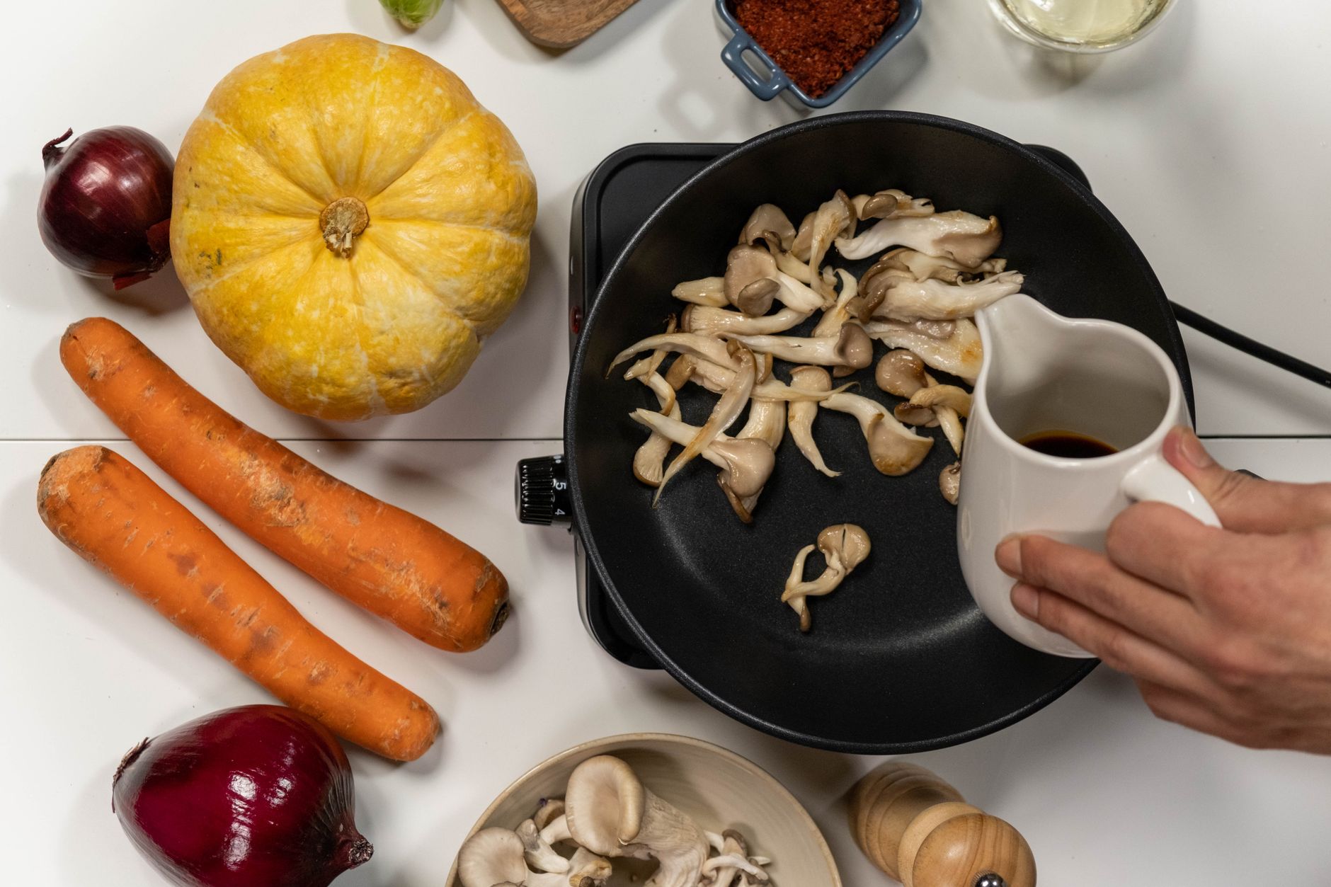Comparación de verduras al cocinar Verduras frescas y congeladas cocinándose en sartenes separadas, ilustrando una comparación directa.