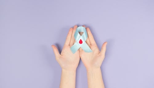 Person Holding A Blue Diabetes Awareness Ribbon With Decorated Blood Drop