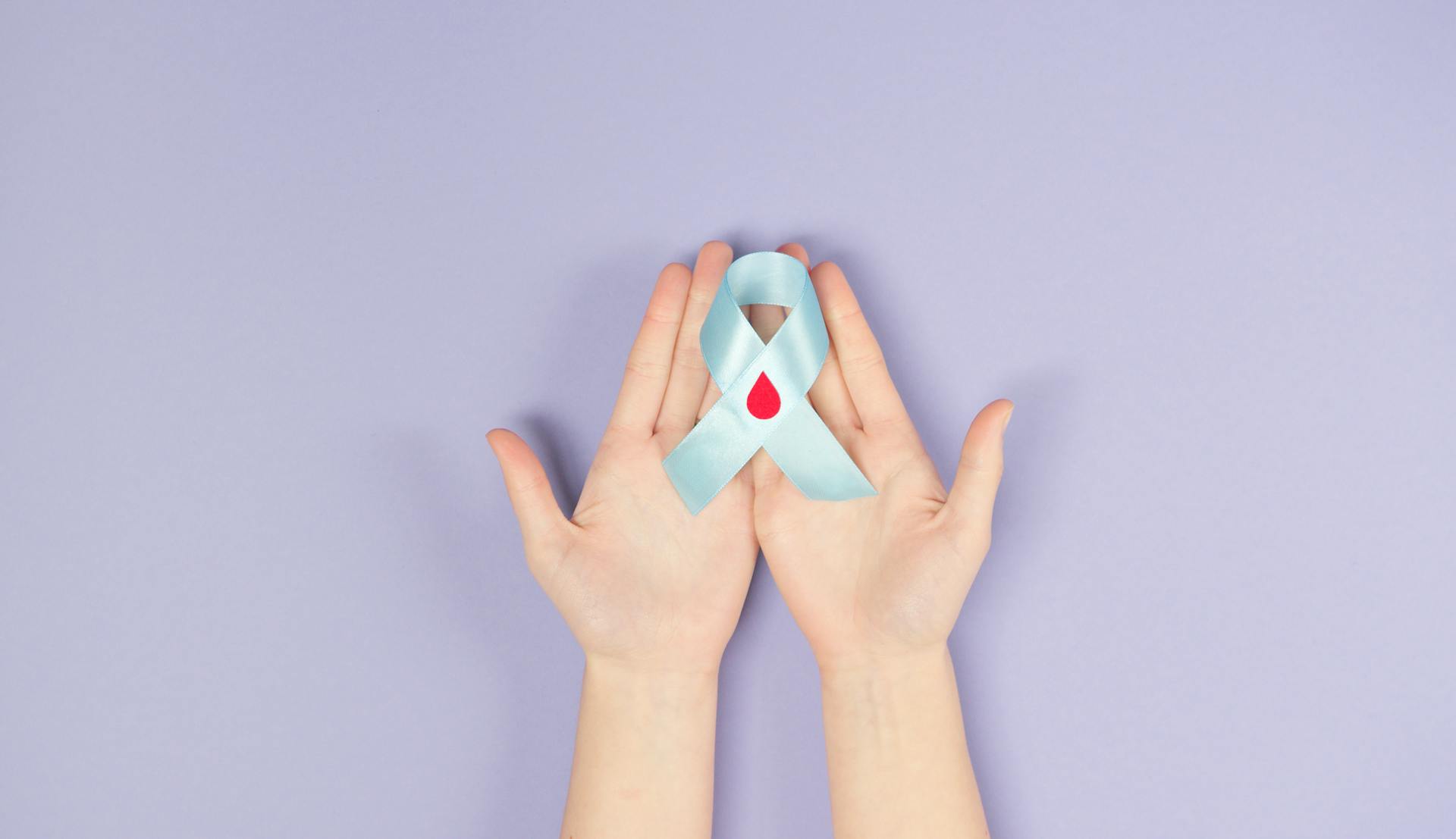 Person Holding A Blue Diabetes Awareness Ribbon With Decorated Blood Drop