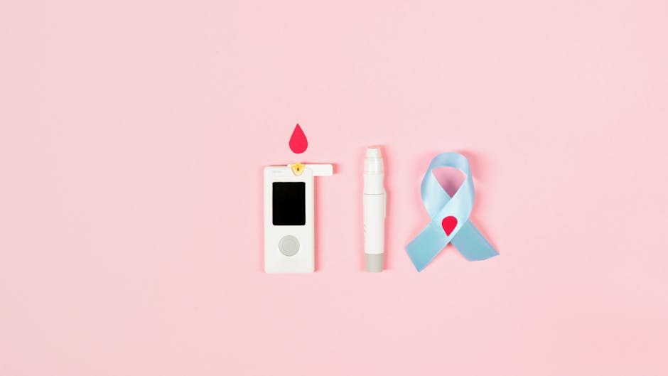 Flat lay of a glucometer, lancet pen, and diabetes awareness ribbon on a pink background symbolizing health awareness.