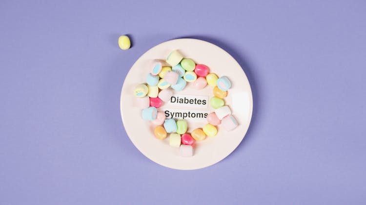 Candies On Plate With Concept On Diabetes Symptoms