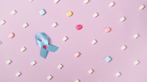 Candies On Pink Background With Blue Diabetes Awareness Ribbon 
