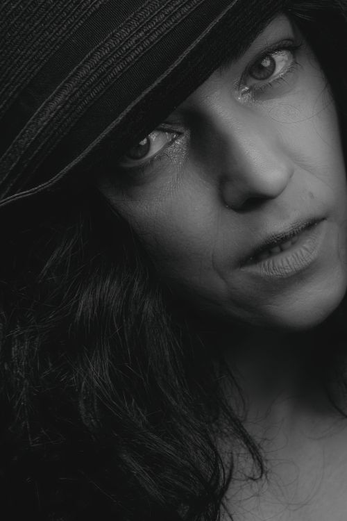 Free Close-up black and white portrait showcasing a pensive woman in a hat. Stock Photo