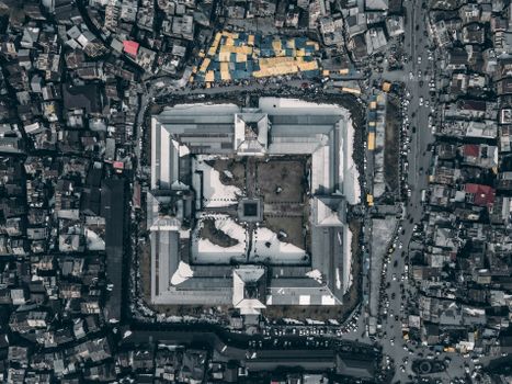 A stunning aerial view of an urban complex with a central courtyard and surrounding buildings.