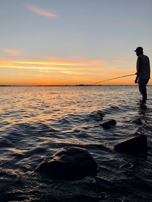 Man Fishing on the Ocean during Sunset