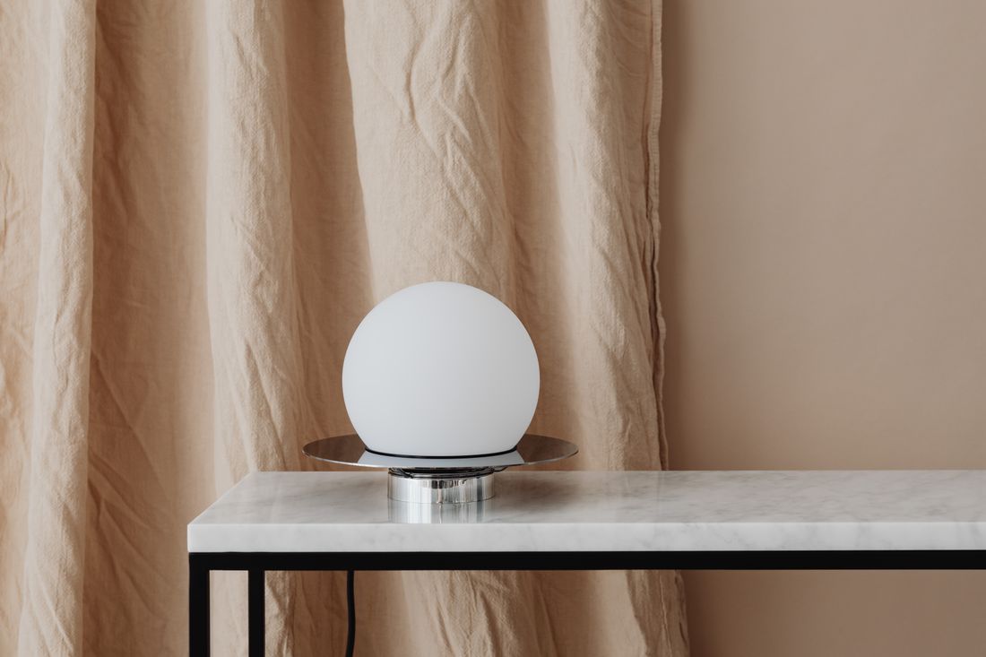 Lampe blanche posée sur une table à plateau en marbre