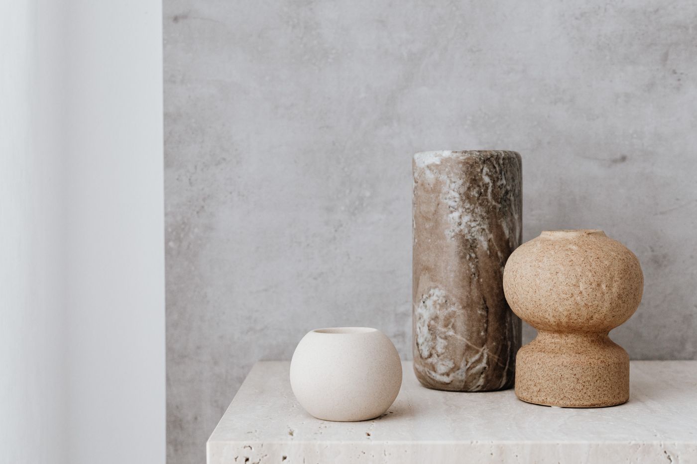 Three ceramic vessels on a stone surface