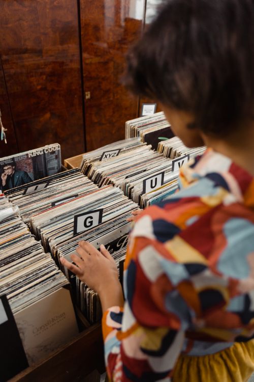 Free A woman looks through vintage vinyl records, creating a nostalgic feel. Stock Photo