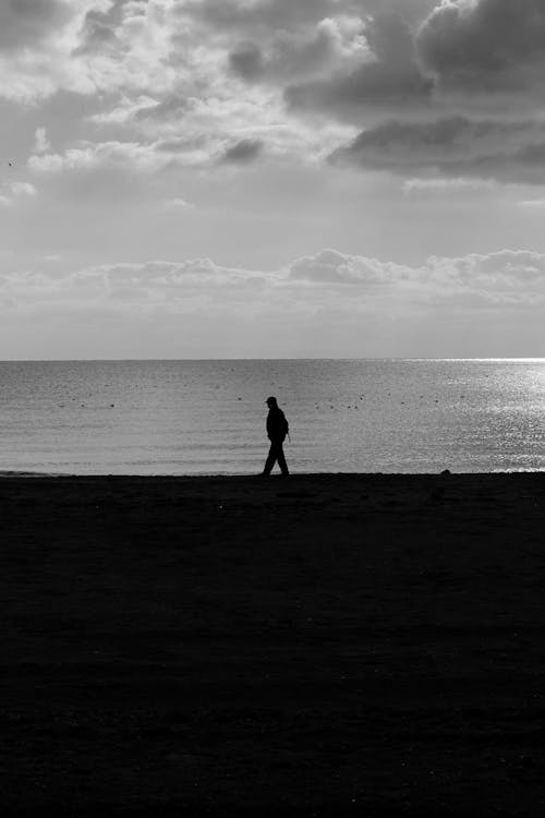 Person Walking on Sea Shore