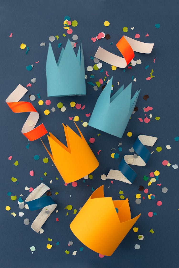 Paper Crowns Over Blue Surface