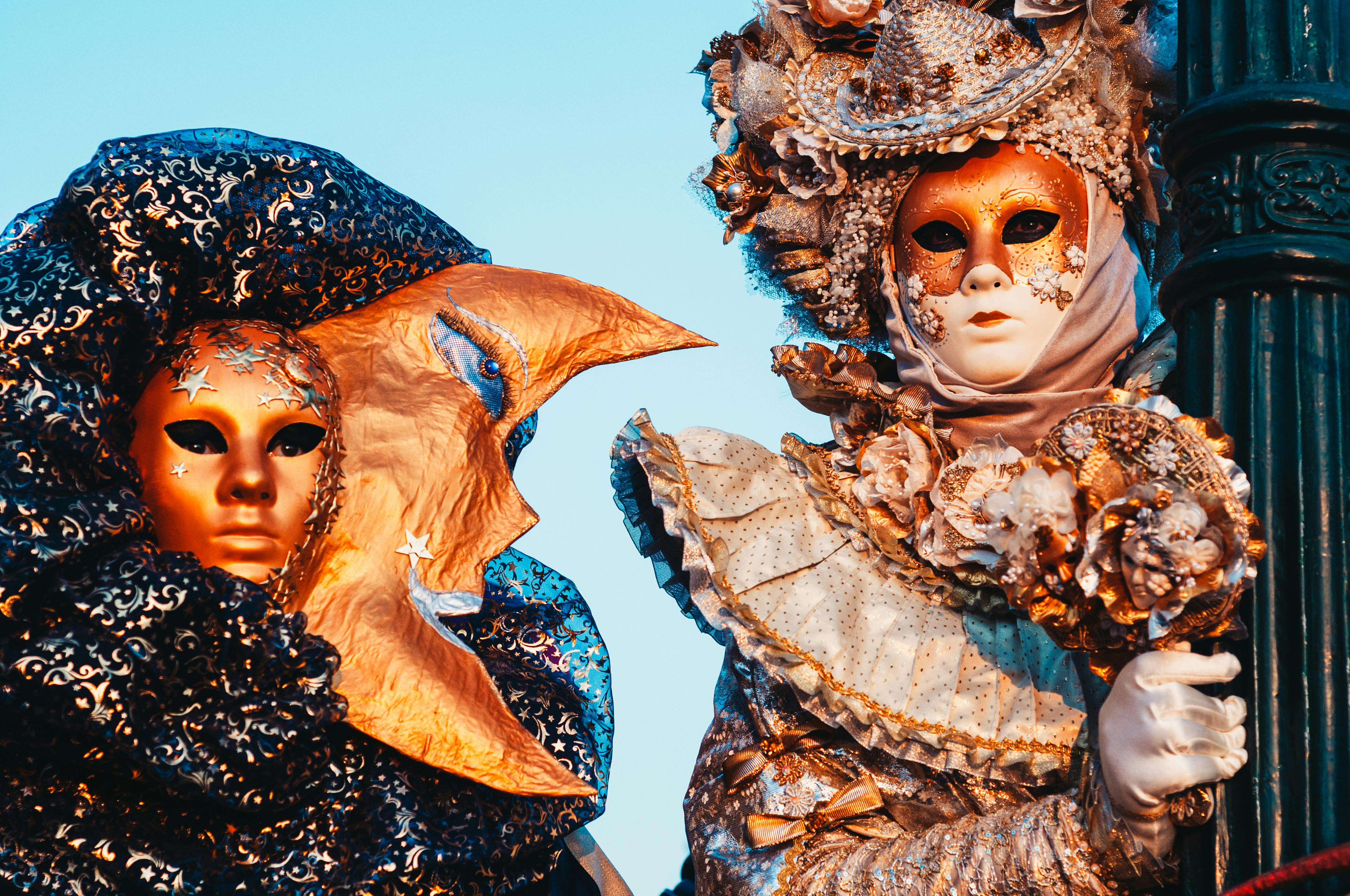 Free Vibrant Venetian costumes and masks at a carnival, showcasing artistic fantasy and celebration. Stock Photo