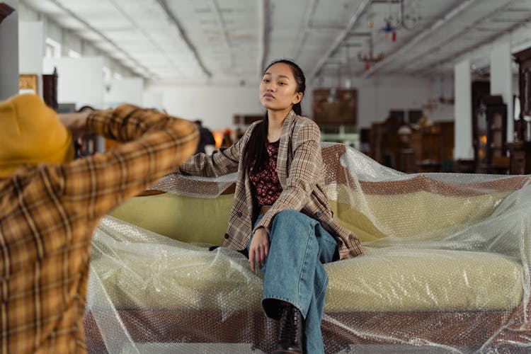 A Woman In Plaid Blazer Sitting The Couch With Bubble Wrap