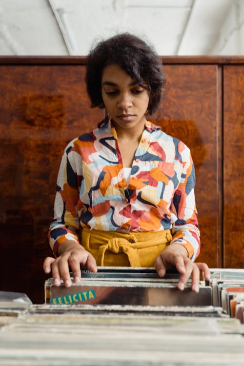 A Woman in Printed Long Sleeves Holding Magazines