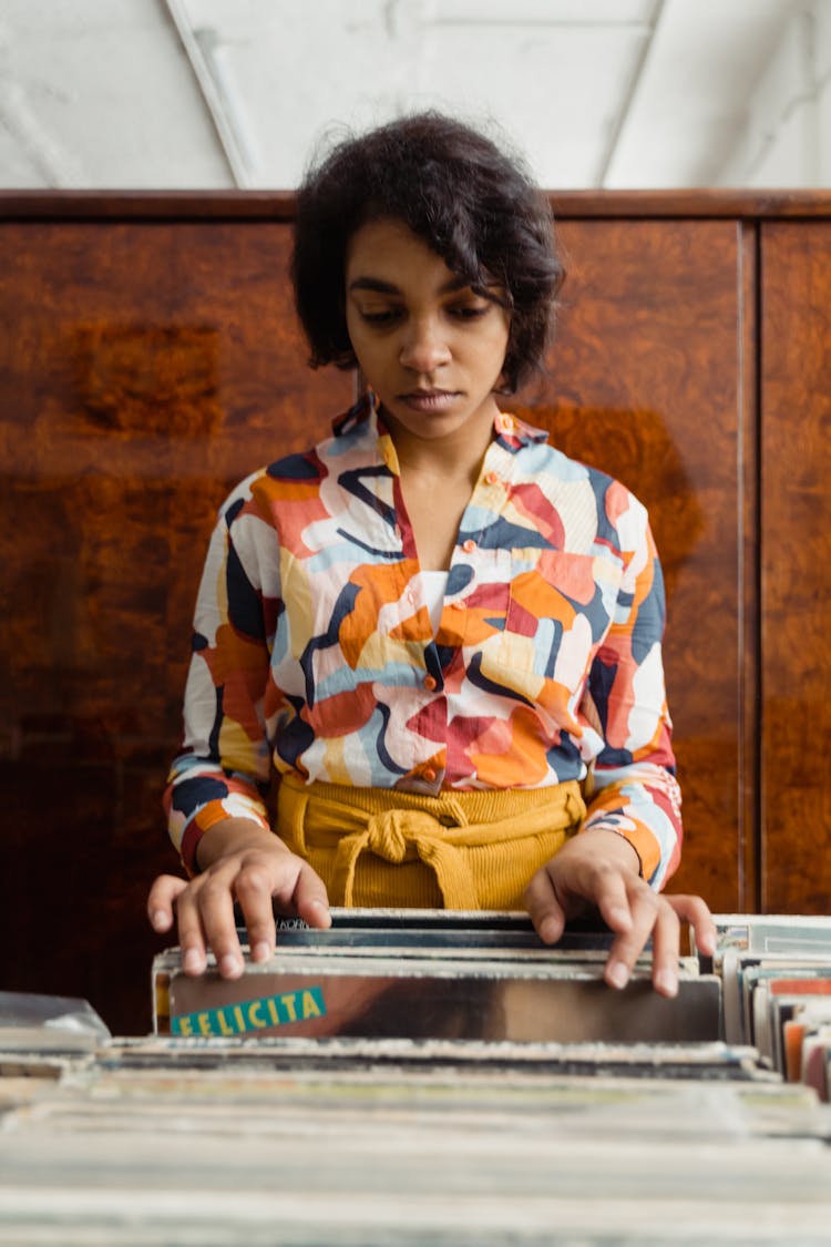 A Woman In Printed Long Sleeves Holding Magazines