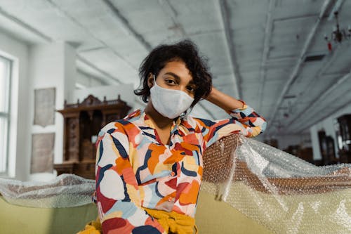 A Woman in Printed Shirt Sitting on a Sofa