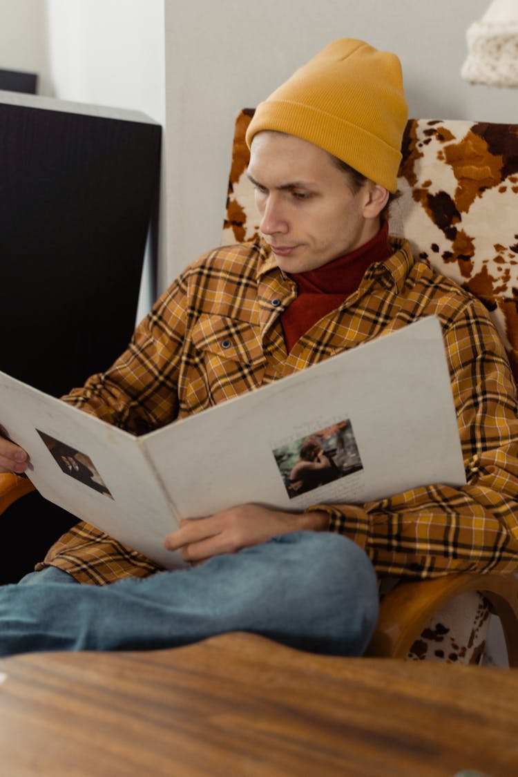 A Man In A Yellow Beanie Reading A Book