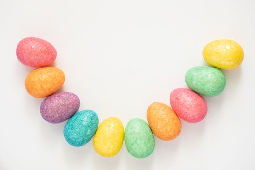 Vibrant arrangement of colorful Easter eggs in a half-circle pattern on a white background., free online jigsaw puzzle on JigsawPuzzlesFreeOnline.org