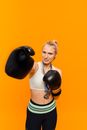 Woman in White Sports Bra and Black Shorts Carrying Black Boxing Gloves