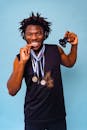 Man with Dreadlocks Posing with Medals on Blue Background
