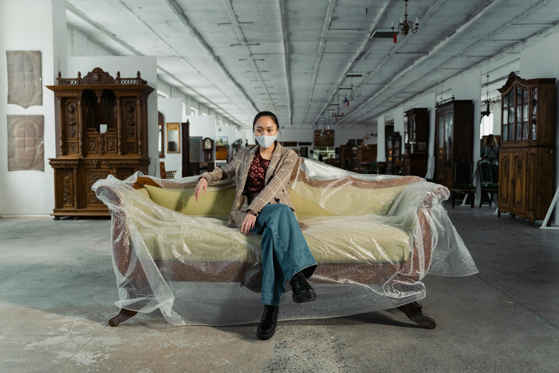 A Woman Sitting on a Plastic Wrapped Sofa