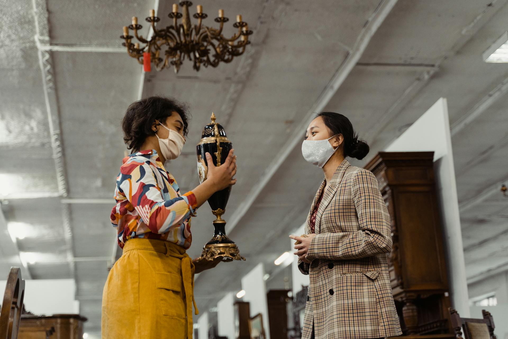 A Woman Showing an Antique Jar to Another Woman