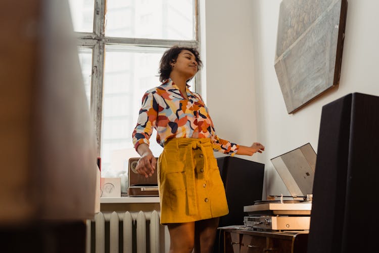 A Woman In Printed Shirt Listening To Vinyl Records Music