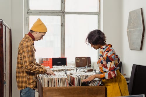 Free A Man and Woman Browsing Through Vinyl Music Records Stock Photo