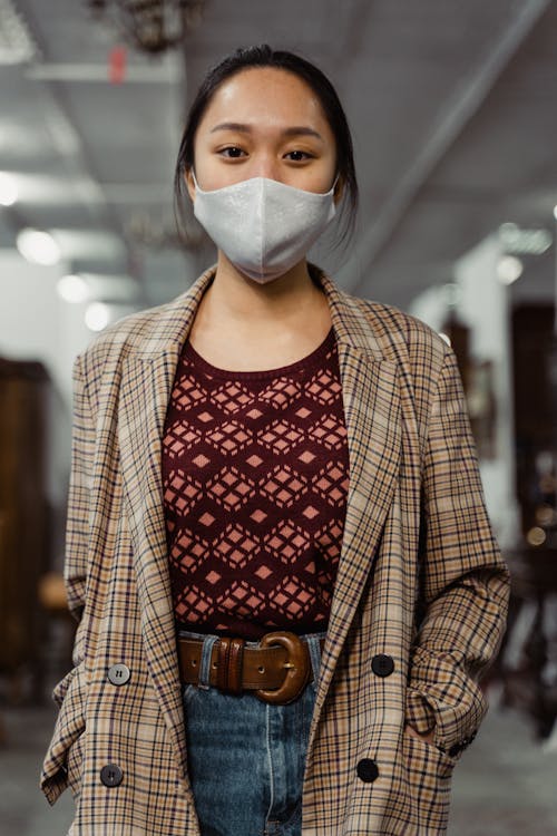 Woman in Plaid Jacket with Hands in Pockets Wearing Gray Face Mask