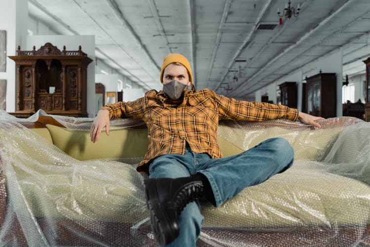 Man In Yellow Plaid Shirt Sitting On The Couch